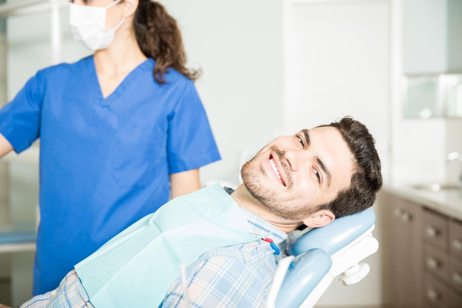 Homem sorrindo na cadeira odontológica antes de realizar cirurgia guiada de implantes em Feira de Santana com a Dra. Camila Freitas.